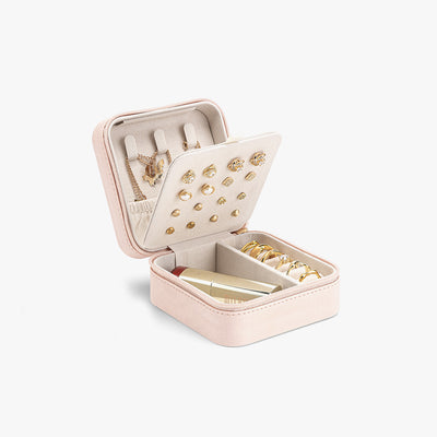 Pink travel jewelry box with velvet lining, ring slots, earring panel and necklace hooks