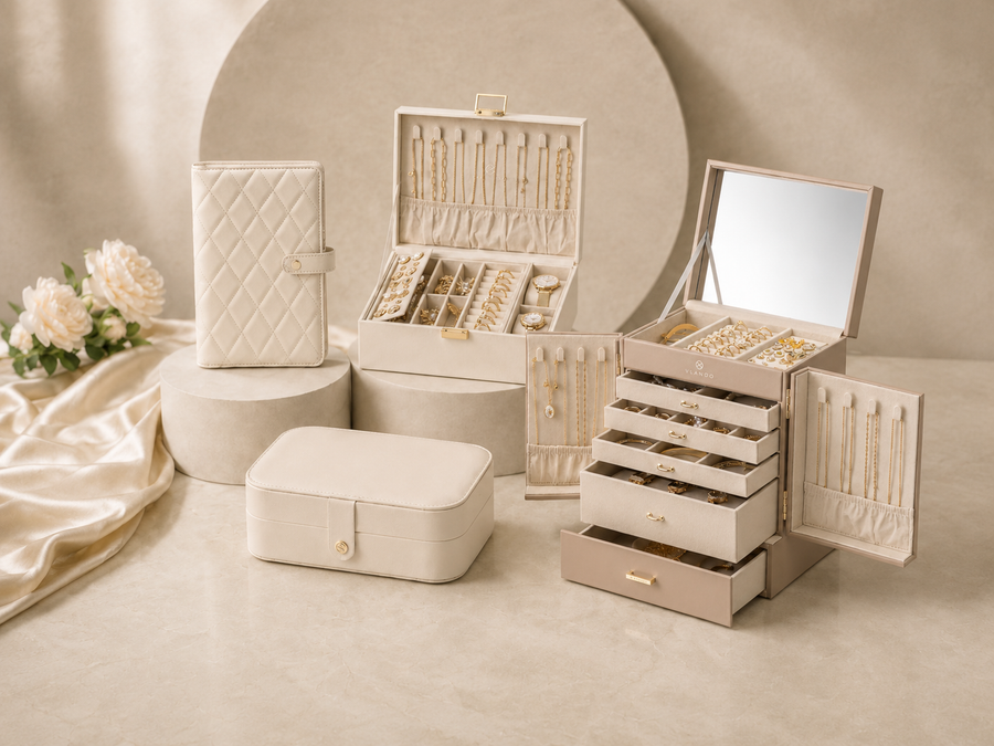 A premium lifestyle scene featuring multiple VLANDO jewelry organizers in cream and beige tones, including stackable drawers and travel cases, displayed alongside flowers and a gift bag to emphasize elegant storage and gifting presentation.